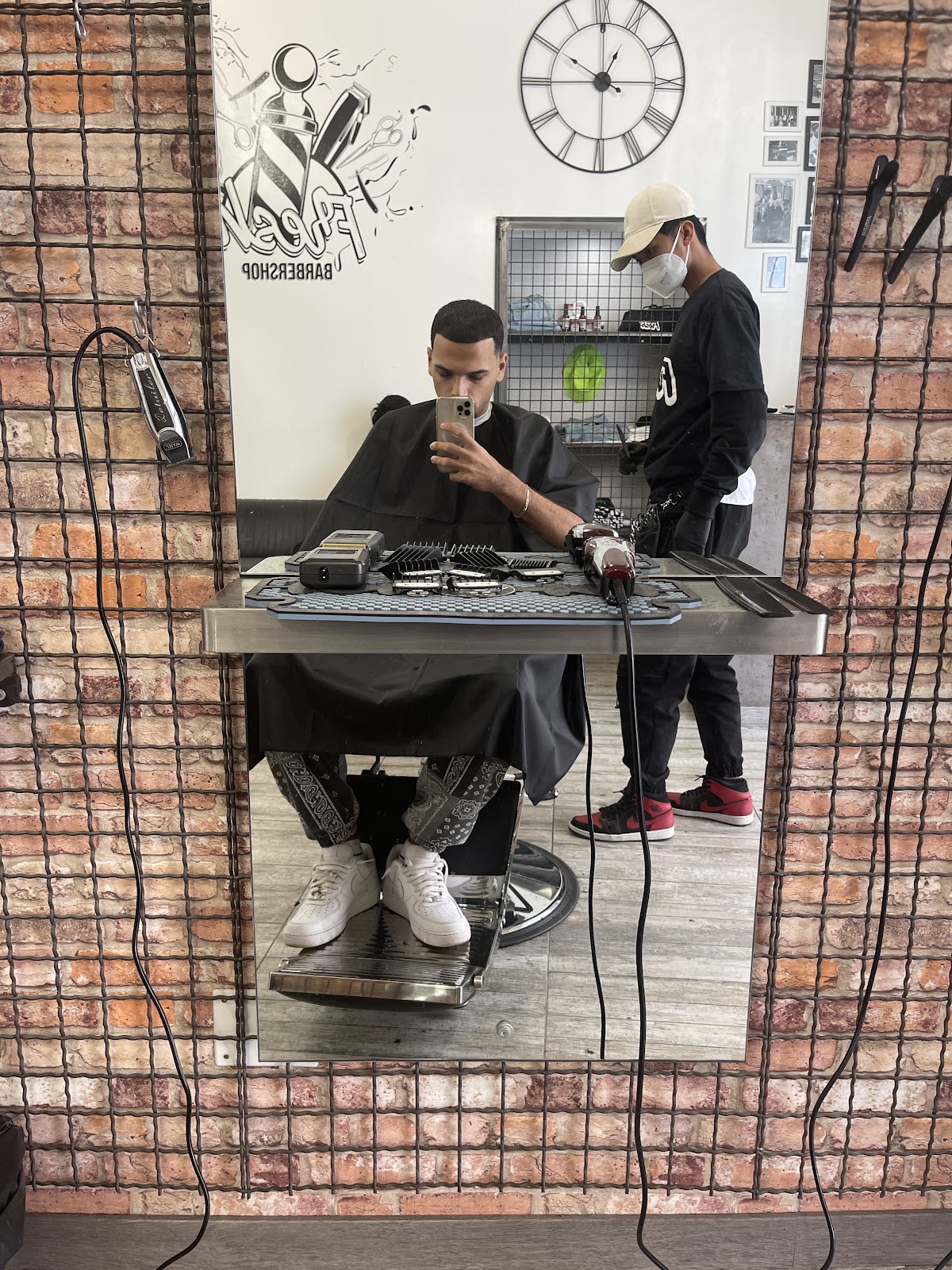 Cliente allo specchio durante il taglio nella postazione del barbershop